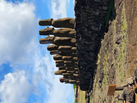       Row of tall Moai statues against a partly cloudy sky on Easter Island
  
