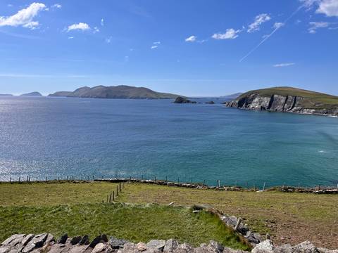       Wide view of blue Atlantic waters, islands and cliffs from a coastal headland on a clear day
  