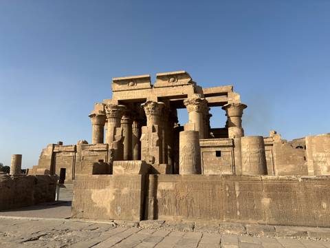       Well-preserved double temple with towering columns and intricate carvings under a clear blue sky.
  