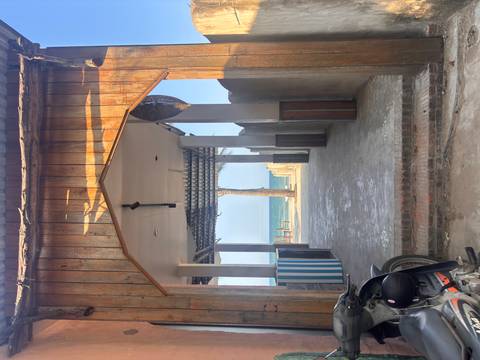       Wood-framed breezeway leads to palm tree and turquoise sea beyond.
  