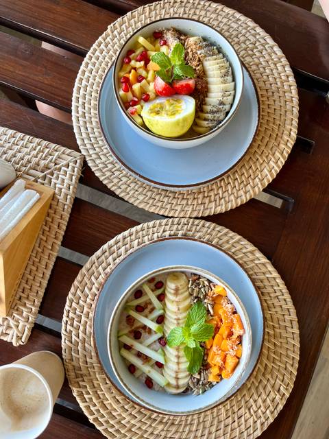      Overhead shot of two stylish breakfast bowls on woven placemats.
  
