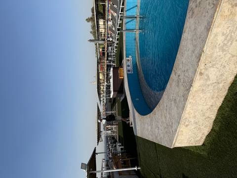       Top deck of a Nile cruise ship featuring a small circular pool and lounge areas under clear skies.
  