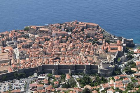      Spectacular aerial view of Dubrovnik’s walled old town jutting into the vivid blue Adriatic Sea.
  