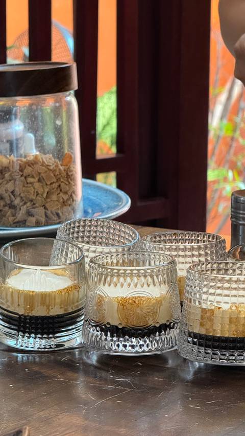       Partially blurred close-up of empty glass tumblers with cereal jar in background.
  