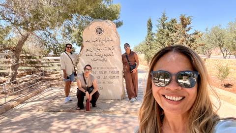       Group poses for a selfie at the Mount Nebo memorial stone surrounded by pine trees.
  