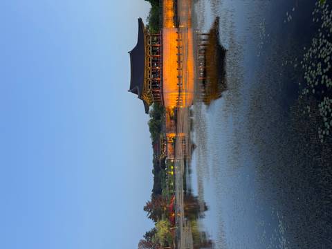       Historic pavilion glowing at dusk, reflecting in the tranquil pond at Wolji in Gyeongju.
  