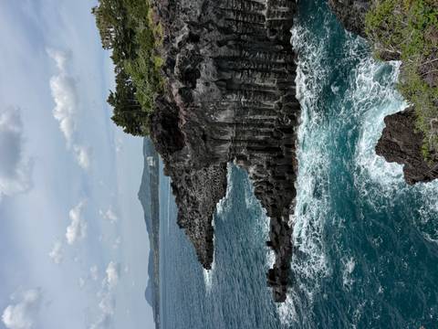       Dramatic basalt column cliffs battered by turquoise waves along Jeju’s rugged coastline.
  