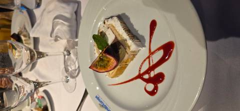       Gourmet plated dessert with passion fruit garnish and raspberry coulis on white china.
  