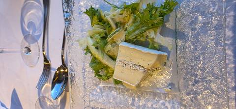       Cheese terrine served with mixed greens on a textured glass plate.
  