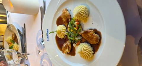       Elegant main dish of poultry with piped mashed potatoes and vegetables in rich sauce.
  