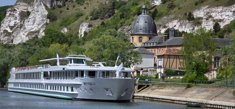       Close-up of cruise ship Botticelli against limestone cliffs and domed chapel.
  