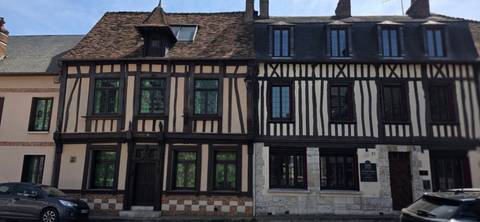       Row of half-timbered medieval houses with patterned brick base.
  
