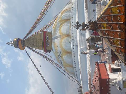       Boudhanath Stupa’s golden spire and all-seeing eyes hover above pilgrims and prayer flags in Kathmandu.
  