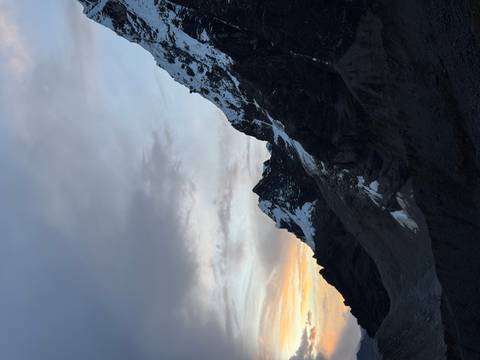       Snow-clad Andes ridge silhouetted at dusk with soft pastel sunset hues in the sky.
  