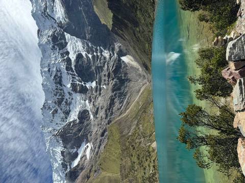       Brilliant turquoise Humantay Lake reflecting snowy peaks and dramatic sky.
  