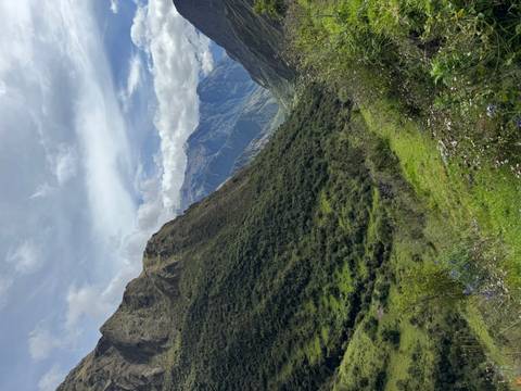       Verdant valley flanked by dramatic Andean peaks beneath a moody sky.
  