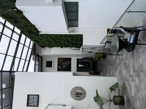       Modern boutique hotel atrium with glass roof, vertical garden wall and minimalist furnishings.
  