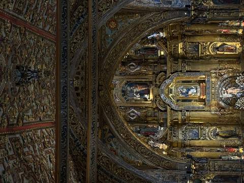       Lavish baroque altar covered in gold leaf and religious statues inside an ornate church.
  