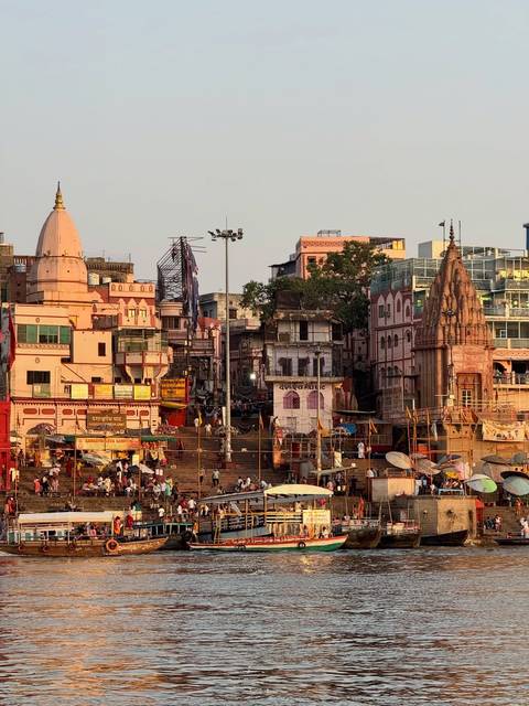       Evening view of crowded ghats, temples and buildings along the Ganges River in Varanasi.
  
