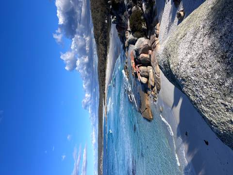       Pristine white-sand beach, granite boulders and vibrant turquoise water under a deep blue sky.
  