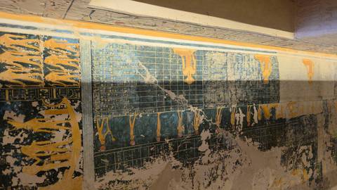       Faded yet intricate star charts and figures decorate the painted ceiling of an ancient tomb.
  