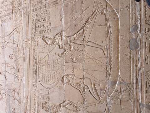      Large wall scene of pharaoh capturing prisoners on sandstone surface.
  
