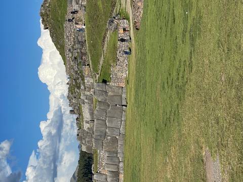       Massive interlocking stone terraces of Sacsayhuaman with visitors exploring the site
  