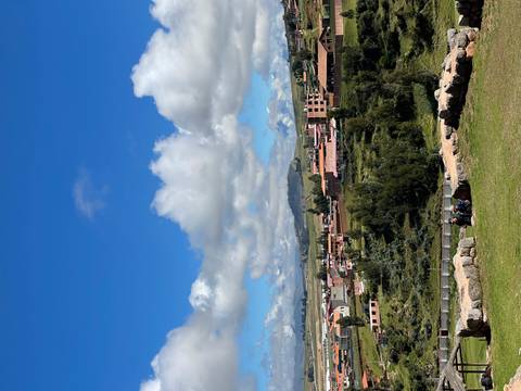       View over rural town and surrounding highland plains beneath scattered clouds
  