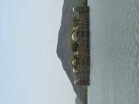       Jal Mahal palace sits serenely in the middle of Man Sagar Lake against a wooded hill backdrop.
  