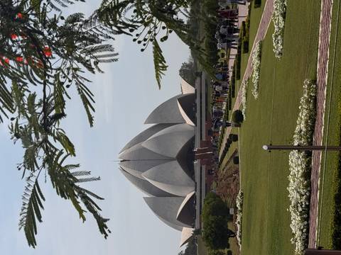       The striking white Lotus Temple rises above manicured gardens in New Delhi.
  