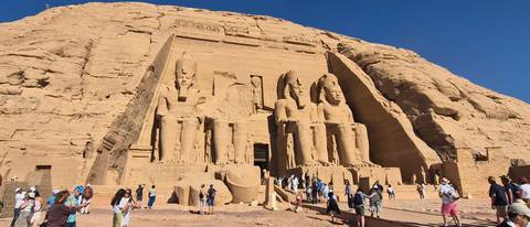       Tourists exploring the colossal statues at Abu Simbel temple complex
  