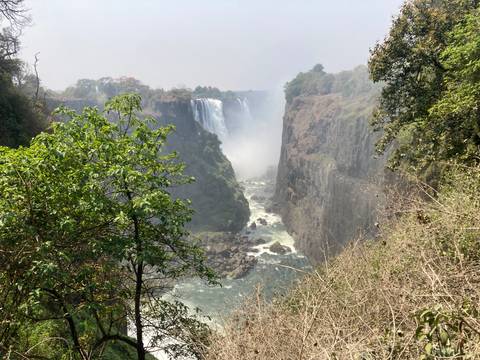       Spectacular view into the gorge of Victoria Falls with powerful water flowing between steep cliffs
  