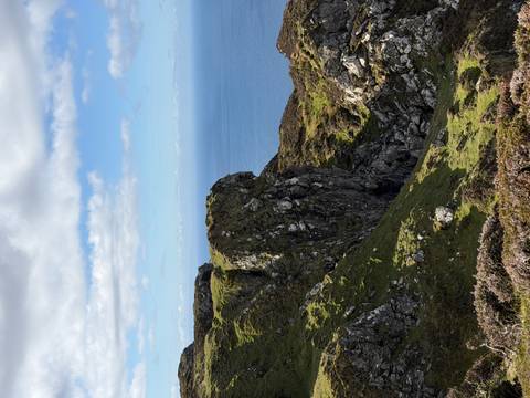       Rocky headland covered in green moss overlooking the vast Atlantic Ocean
  