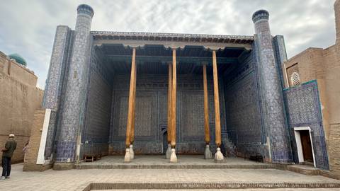       Wood-columned hypostyle hall of the Juma Mosque in Khiva with blue-tiled walls
  