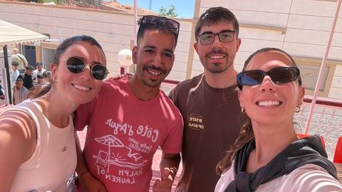       A smiling group of four friends posing for a sunny selfie in Morocco
  