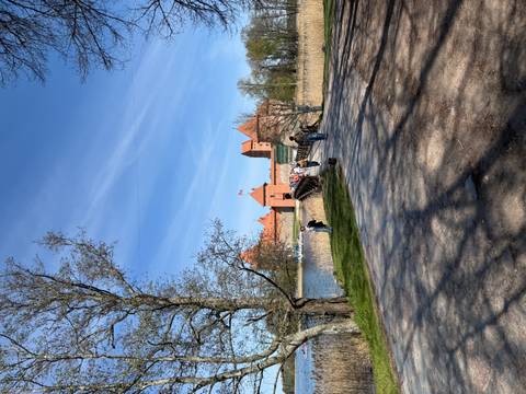       Pedestrian bridge leading to Trakai Castle across a shimmering lake on a sunny day.
  