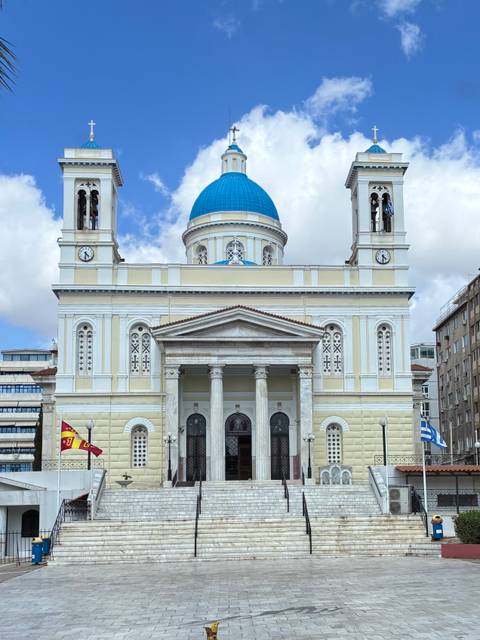       A grand three-storey church with a bright blue dome, twin bell towers and classical columns dominates the square.
  