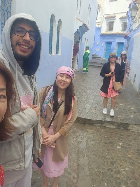       Travellers explore blue-washed lanes; candid shot shows motion blur and casual atmosphere.
  