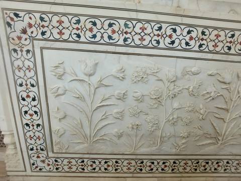       Close-up of white marble floral inlay and carving with intricate border patterns
  