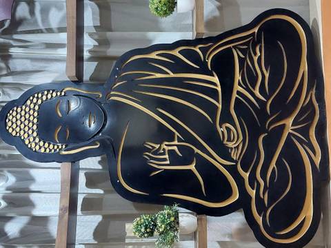       Stylized metallic silhouette artwork of a seated Buddha on display indoors
  