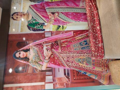       Large poster displaying two women wearing richly embroidered traditional saris
  