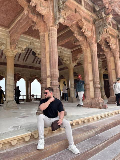       Travellers explore the intricately carved sandstone columns and arches of Fatehpur Sikri palace complex.
  