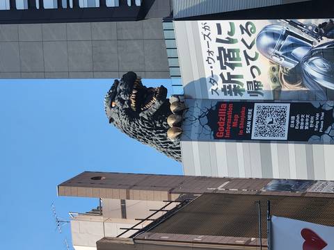       Iconic Godzilla head sculpture looming over a Shinjuku building façade
  
