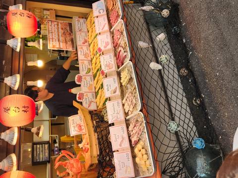      Street food vendor in Japan selling an array of fresh seafood skewers and snacks
  