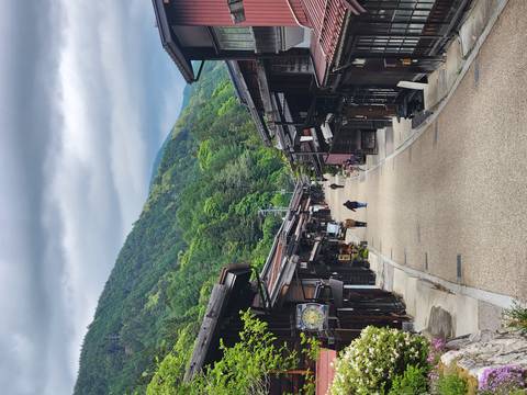       Quiet traditional wooden street in a mountain village with lush hills in the background
  