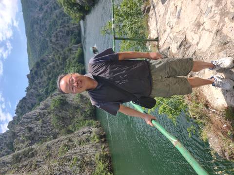       Man standing on a rocky path above the emerald waters of Matka Canyon.
  