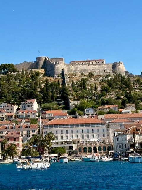       View of the Spanjola Fortress crowning a hill above Hvar town’s orange rooftops.
  