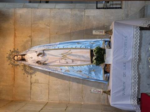       Statue of Virgin Mary dressed in blue inside stone chapel altar.
  