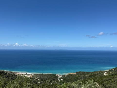       Minimalist view of deep blue open sea meeting a clear horizon beneath a cloud-dotted sky.
  