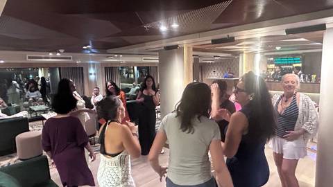       Passengers dancing and socializing in the lounge of a Nile river cruise ship
  